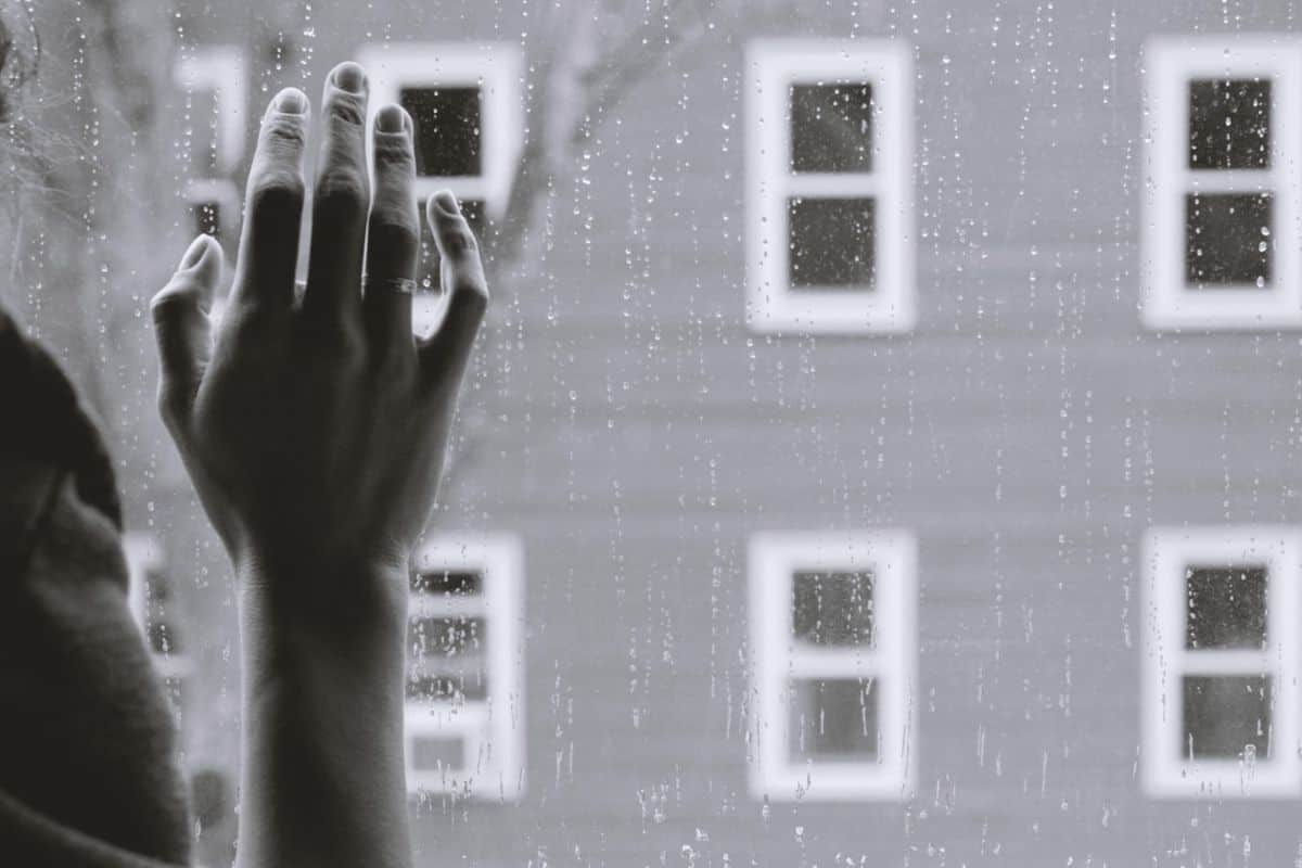 hand on window looking out